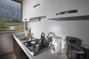 德罗Appartamenti Al Vigneto的厨房配有炉灶、水槽和窗户。
