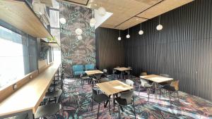 塞格德Noir Hotel的用餐室配有桌椅和壁画