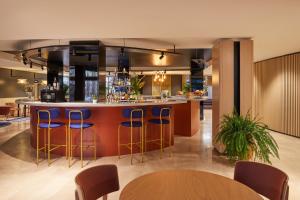 马德里Crowne Plaza Madrid - Centre Retiro, an IHG Hotel的厨房设有带蓝色凳子的酒吧