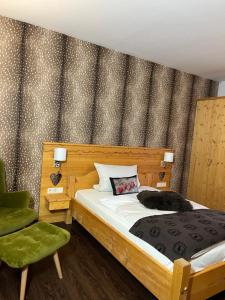吕登沙伊德斯波特艾姆吉费卢克酒店的一间卧室配有一张床和一把绿色椅子
