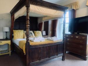 卡斯尔顿Ye Olde Nags Head的一间卧室配有一张天蓬床和一台电视机