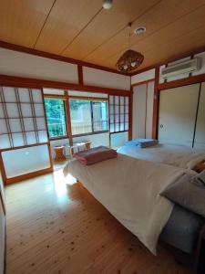 Inoそらやまゲストハウス Sorayama guesthouse的一间带一张大床的卧室,位于带窗户的房间内