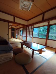 Inoそらやまゲストハウス Sorayama guesthouse的客房设有桌子和窗户。