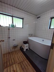 Inoそらやまゲストハウス Sorayama guesthouse的浴室配有白色浴缸和淋浴。