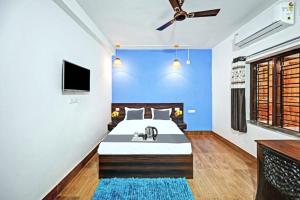 布巴内什瓦尔Goroomgo Madison Blue Bhubaneswar的一间卧室配有一张带水槽和蓝色墙壁的床。