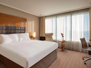 希灵登索菲特伦敦希斯罗酒店的酒店客房设有一张大床和一张书桌。