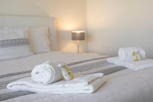 佩拉TAC - Pêra Gardens Villa的酒店客房的床铺上备有毛巾