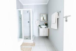米德兰Central Serenity @Midrand的带淋浴和盥洗盆的白色浴室