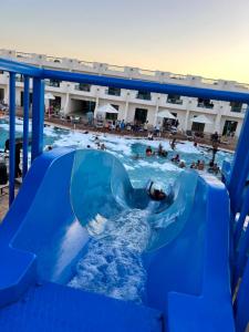 沙姆沙伊赫Sharm Cliff Hotel的一个人在游泳池里骑水滑梯