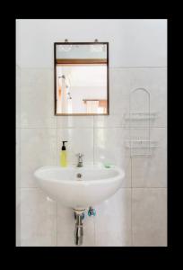 乌布乌布阿尔加旅馆的浴室设有白色水槽和镜子