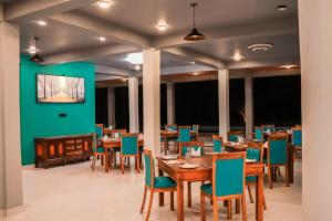 卡尔皮蒂耶Hiru Beach Resort的用餐室配有木桌和蓝色椅子