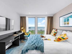 佩恩顿ibis Styles Paignton的酒店客房设有一张床、一张书桌和窗户。