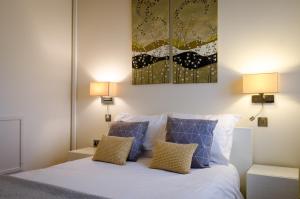 科姆堡如家老屋酒店的一间卧室配有一张带两盏灯和一幅画的床铺