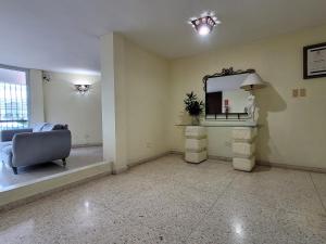 拉罗马纳Hotel Olimpo的客厅配有镜子和椅子