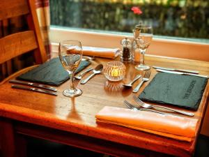 博斯卡斯尔滨江酒店的一张木桌,配有叉子、眼镜和餐巾