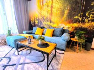 班斯科6 Luxury SPA Apartments TOP resort Bansko - incl wellness的客厅配有蓝色沙发和绘画作品