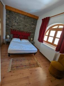 Villar-dʼArèneGîte Neige Cordier - Villar d'Arène center 2 bedrooms and large terrace的一间卧室设有一张床和砖墙