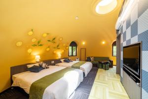 越生町BIO-RESORT HOTEL & SPA O Park OGOSE的配有两张床铺、黄色墙壁和电视的客房