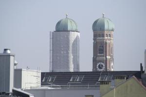 慕尼黑迪马斯市酒店的一座有钟楼和两座高楼建筑的建筑