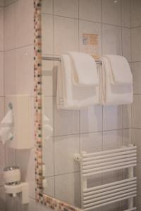 特翁Landhotel Postgut - Tradition seit 1549的带淋浴和白色毛巾的浴室
