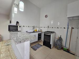博阿维斯塔Apto novo, mobiliado e acochegante的白色的厨房配有炉灶和水槽