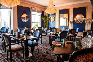 兰迪德诺兰迪德诺湾酒店 的一间设有桌椅的餐厅,位于拥有蓝色墙壁的房间