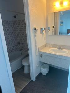 滨海卡尔顿卡尔顿瑟迈汽车旅馆的一间带水槽、卫生间和镜子的浴室