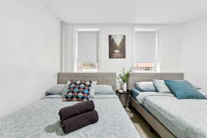 纽约Peaceful Apartment in Lower Manhattan New York的一间卧室设有两张床和两个窗户。