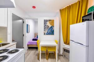 纽约Peaceful Apartment in Lower Manhattan New York的小厨房配有白色的桌子和黄色的椅子