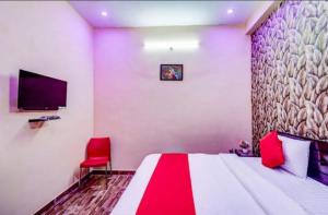 勒克瑙Shri Radhe Krishna Bhawan的一间卧室配有一张大床和一张红色椅子