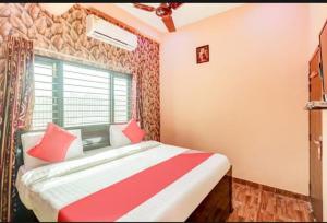 勒克瑙Shri Radhe Krishna Bhawan的一间卧室配有红色和白色床单