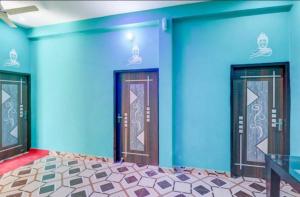 勒克瑙Shri Radhe Krishna Bhawan的一间设有蓝色墙壁、两扇门和一张桌子的房间