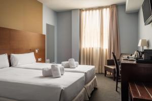 略夫雷加特河畔奥斯皮塔莱特马达尼斯酒店的酒店客房配有两张床和一张书桌