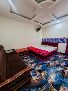 德奥加尔Parinay Vatika Inn的一间位于地板上的卧室,配有一张床和一张沙发