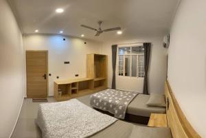 幸福岛Dhonveli Inn, Bandidhoo的一间小卧室,配有两张床和一张书桌