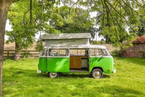 Great OuseburneDub Indie - The 100% Electric Classic Camper的停在田野的一辆旧绿色货车