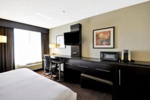 罗缪勒斯Holiday Inn Express Romulus / Detroit Airport, an IHG Hotel的配有一张床和一张书桌的酒店客房