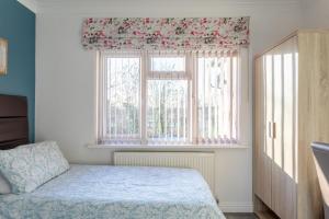巴尔内特Apple House Wembley的一间卧室设有一张床和一个窗口