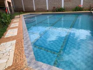 内罗毕Spire Plaza 2 bedroom apartment的庭院里的一个蓝色海水游泳池