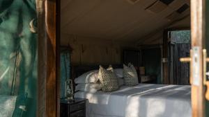 LentswelemoritiMashatu Tent Camp的一间卧室配有带枕头的床