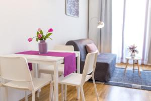 布达佩斯Colours Apartments Deluxe with FREE Parking的用餐室配有桌椅和紫色的桌布