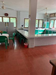 科韦尼亚斯Cabaña Coveñas Los García的厨房配有带绿色椅子的柜台和游泳池。