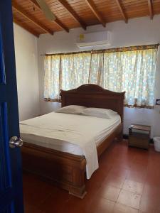 科韦尼亚斯Cabaña Coveñas Los García的一间卧室配有一张带木制床头板的床和窗户。