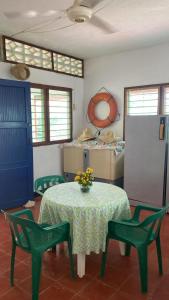 科韦尼亚斯Cabaña Coveñas Los García的一间设有桌子、两把椅子和一张鲜花桌的房间