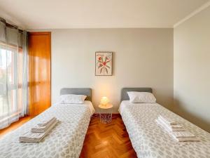 维亚纳堡Comfortable apartment in Viana do Castelo的两张睡床彼此相邻,位于一个房间里