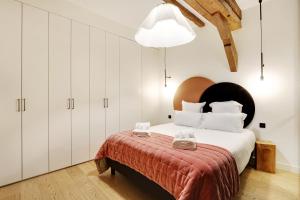 巴黎Pick A Flat's Apartments in Place des Vosges - Rue de Birague的一间卧室配有一张带白色橱柜的大床