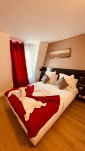 巴黎杰夫酒店的一间卧室配有一张带红色窗帘的大床