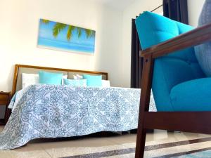康隆尼角Residence Le Point Choisy的一间卧室配有蓝色的床和蓝色椅子