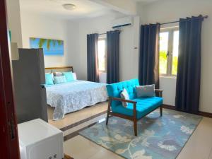 康隆尼角Residence Le Point Choisy的一间卧室配有一张床和一张蓝色椅子