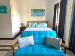 康隆尼角Residence Le Point Choisy的一间卧室配有蓝色的沙发和一张床